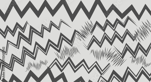 Abstract design featuring overlapping, stylized zigzag patterns in varying shades of gray.