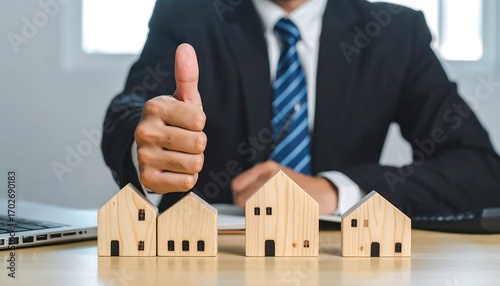 Approval gesture towards charming miniature house models symbolizes success