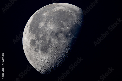 Fotografija half moon on black background with crater detail