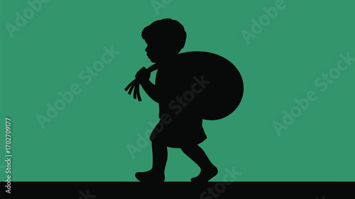 Silhouette of a young boy carrying a bundle over his shoulder on green background creates a vintage feel