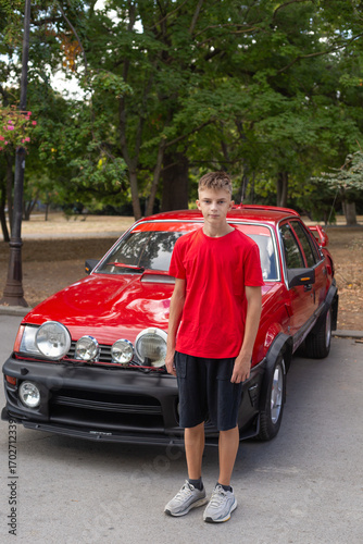 Фототапет boy in car. a teenager with a classic red car
