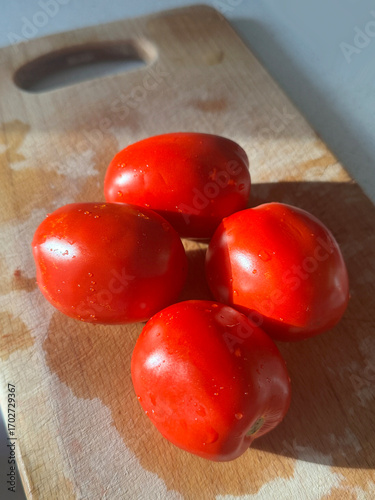 red tomatoes on a wooden board