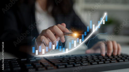 Canvas-taulu A close-up of a professional hand conducting a financial analysis using data charts and keyboard in an office, representing growth, investment strategies, and technology