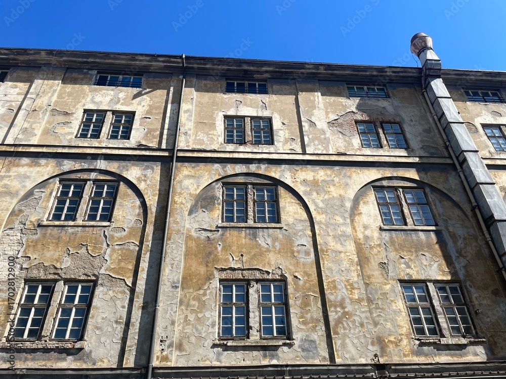 Fototapeta premium A very large building that features numerous windows and has a prominent chimney situated on its roof, visible from various angles