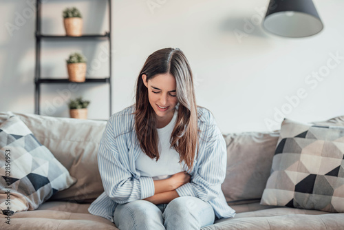 Free Download One woman suffering from stomachache alone at home, holding her belly, touching and massaging abdomen. Bad sick face feeling discomfort and diarrea - GFXLoad