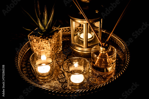 Cozy candlelight arrangement with lantern, diffuser, and decor on ornate tray — perfect for lifestyle, spa, or relaxation themes