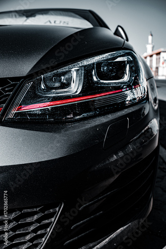 Modern car headlight close-up with sleek design and red accent line, perfect for automotive branding and tech ads