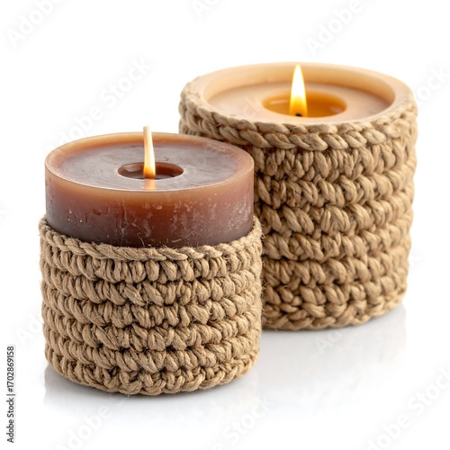 Two brown candles in beige crocheted holders on a white background