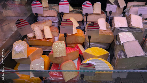 Assortment of artisan cheeses from Mallorca and Menorca in supermarket. Balearic Islands products, cured and semi-cured cheese, Spanish food, groceries, gourmet, consumer goods, retail display.