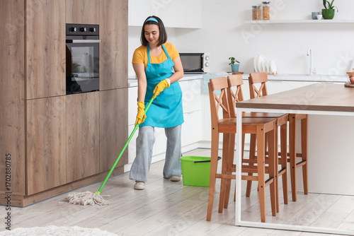 Young woman mopping floor i...
