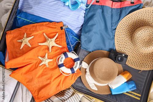 Open suitcase with men's sw...