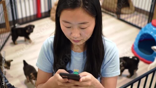 Wallpaper Mural Young woman interacts with her smartphone surrounded by playful cats and dogs at home Torontodigital.ca