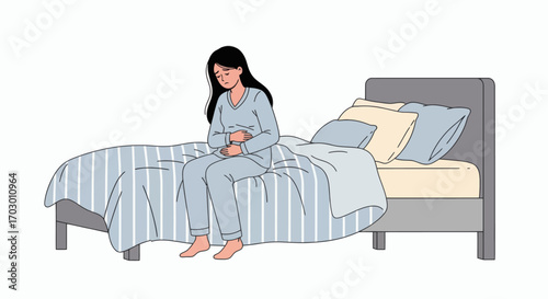 A sad woman in blue pajamas sits on a bed holding her stomach with striped bedding and pillows