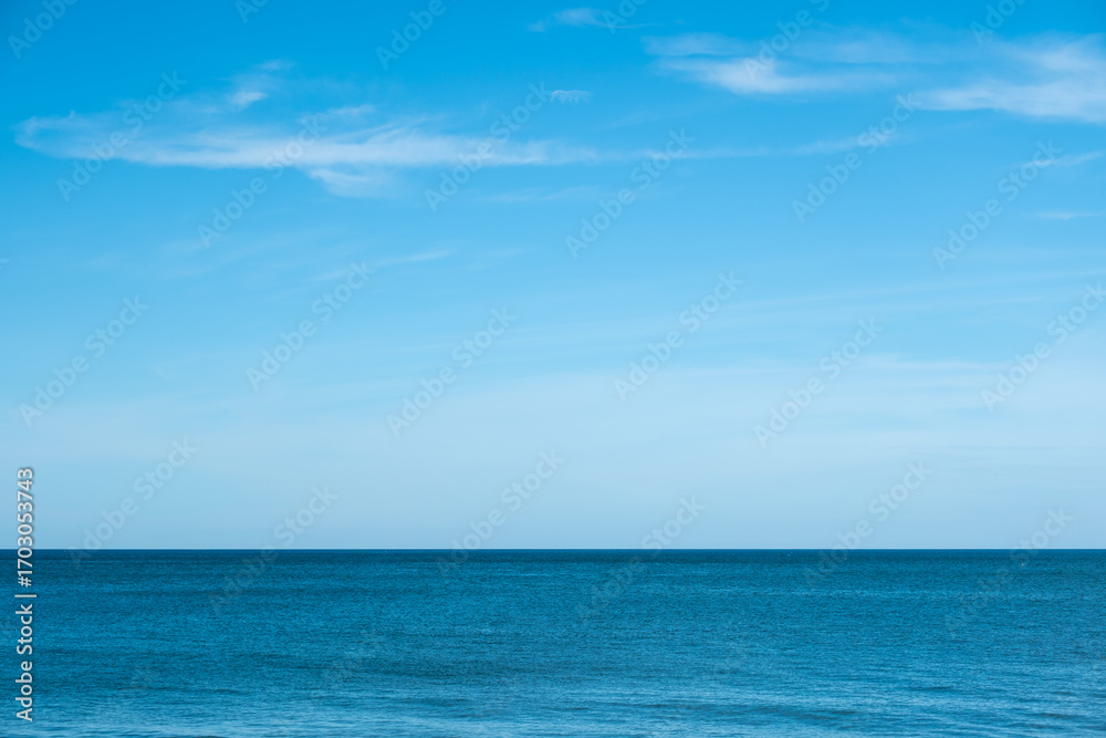Obraz premium Nature of the ocean and blue sky Summer with sunshine, sandy beaches, clear blue waters sparkling against the blue sky. on an island with good ecology and environment Background for summer vacation