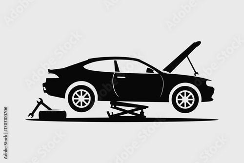 Black car lifted on jack with hood open and tools vehicle repair