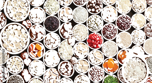 Overhead shot of a variety of dried fruits nuts and seeds displayed in small wooden bowls creating a colorful and textured food background for healthy eating concepts
