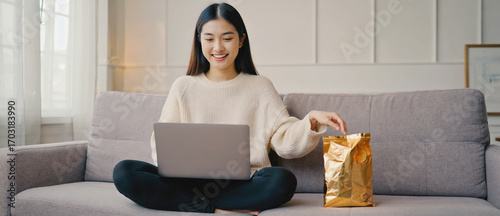 Cozy Corner: A young woman lounges contentedly on a plush sofa, laptop in lap, with a radiant smile suggesting an engaging online experience and relaxing home setting. 