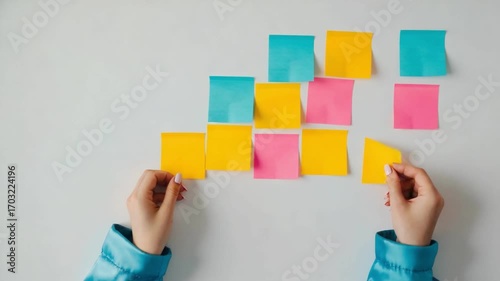 Colorful Note Planning: Hands meticulously arrange and organize a collection of vibrant sticky notes on a surface, illustrating the core elements of organization and prioritization. 