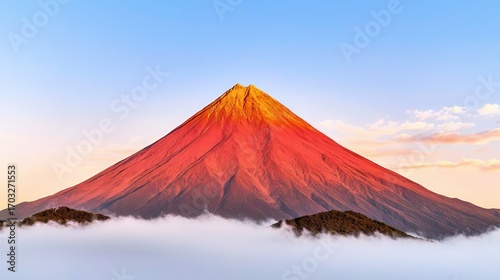 Majestic Mountain Peak at Sunrise Over Soft Clouds with Vibrant Colors in Blue Sky