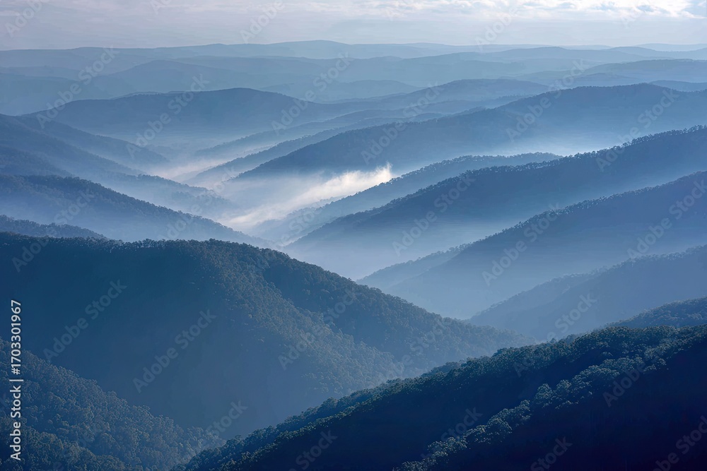 Fototapeta premium Misty mountain ranges, soft blue hues