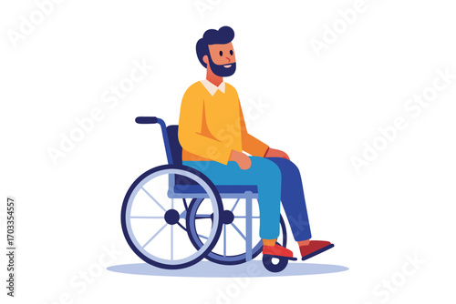 Bearded man wearing a yellow shirt rides wheelchair and looks right against plain backdrop