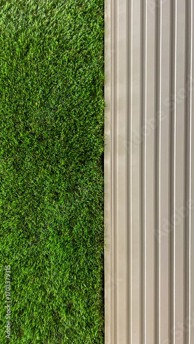 Fotografie Artificial Green Grass Wall And Vertical White Panels, Captured Indoors, Daytime