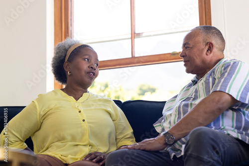 Фотография African American senior couple sitting on couch, having heartfelt conversation