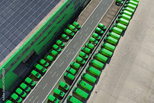 Delivery vans hub with solar panel on a roof. Fleet of green vehicles