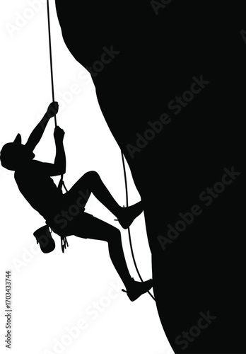 Silhouette of climber ascending rock face rock climbing