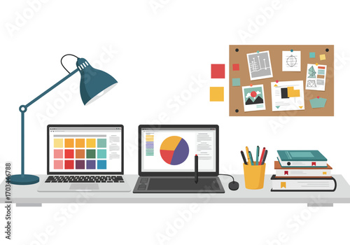 A graphic designers desk setup with laptops a lamp and bulletin board