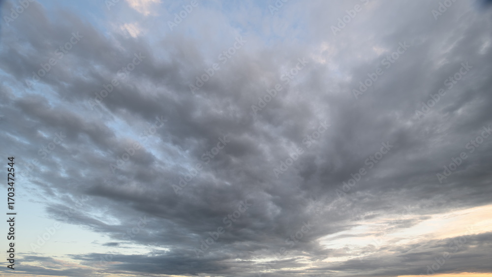 Fototapeta premium Stunning and Dynamic Cloud Patterns Appearing at Sunset in a Beautiful Landscape Scene
