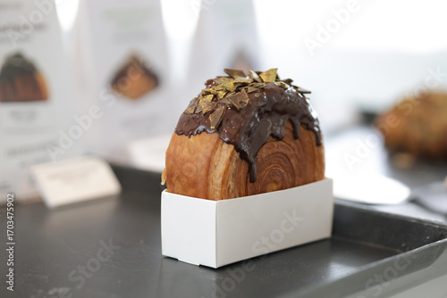 Cromboloni with chocolate topping coating on top. Chocolate Croissant with blurred background.