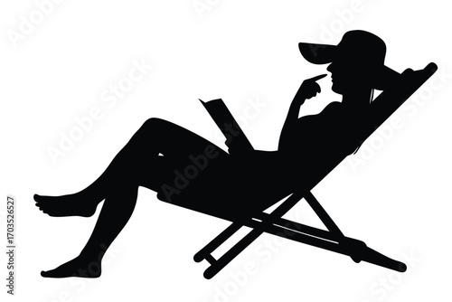 Silhouette of a woman reading a book while relaxing in a deckchair wearing a hat