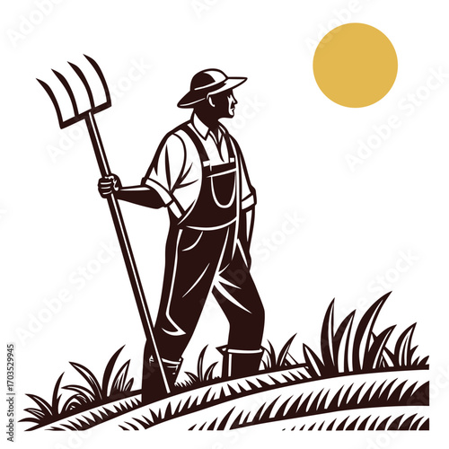 Farmer wearing overalls with pitchfork surveys his field during a warm sunny morning