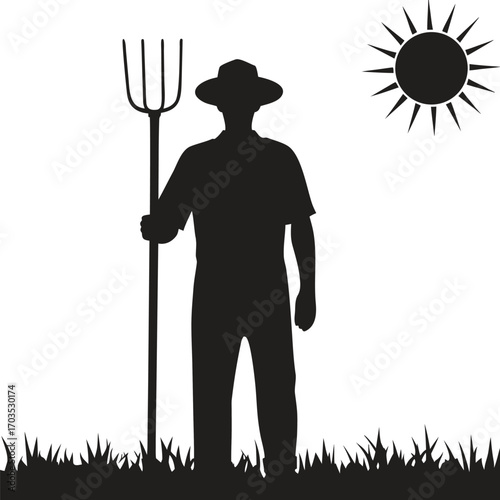 Silhouette of male farmer standing with pitchfork under the sun amidst grass