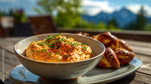 Delicious Obatzda And Fresh Pretzels On A Rustic Wooden Table, With The Scenic Bavarian Alps In The Distance