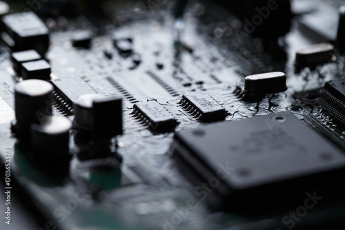 Close up of dark circuit coard with microchips and electronic components
