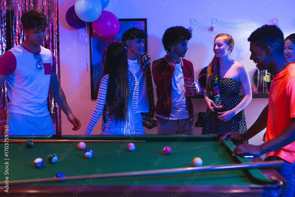 Naklejka premium Teenagers enjoying lively pool game at home party with colorful decorations