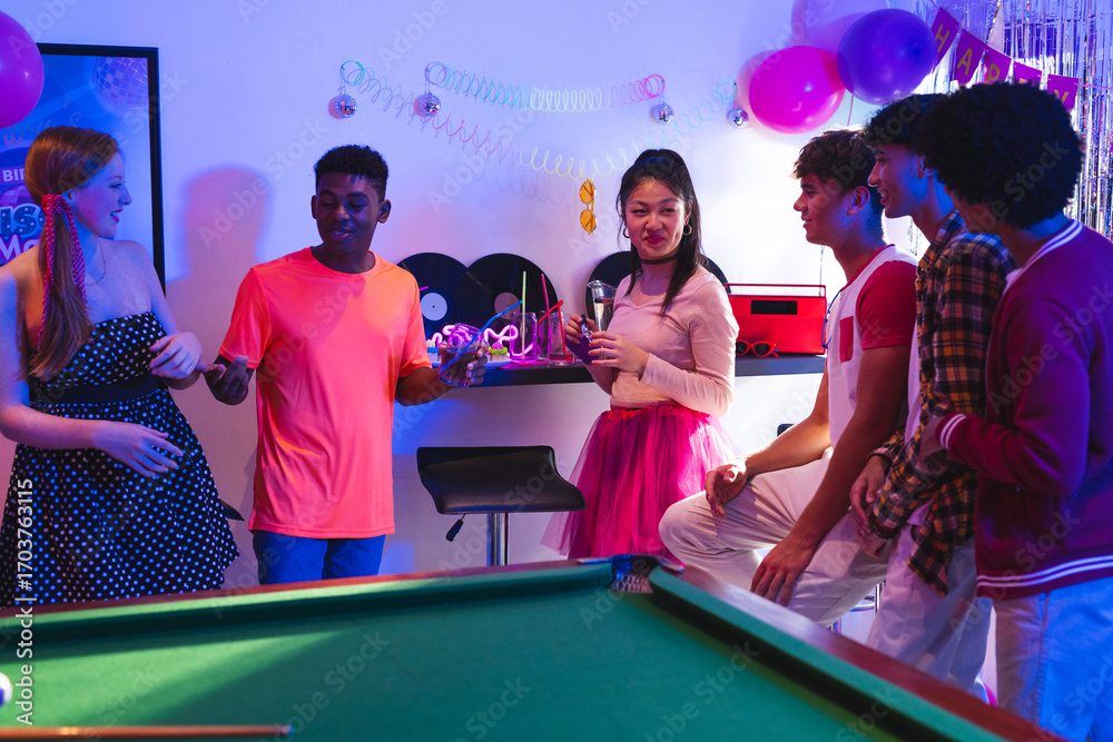 Obraz premium Teenagers enjoying lively party with drinks and laughter around pool table