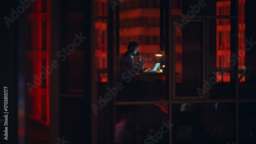 Fotografía Night businessman silhouette window working alone at night talking smartphone