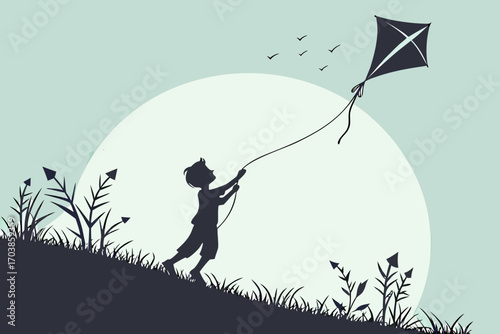 Silhouette of a boy flying a kite on a hillside with birds