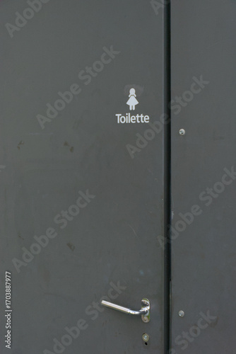 A minimalist female restroom sign, with a silhouette and the German word 