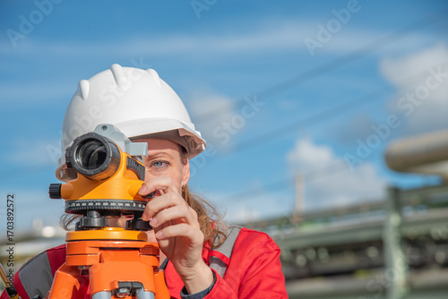 Woman engineer using theodolite outdoors