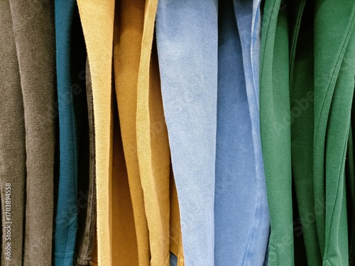 Colorful collection of neatly hung clothing showcasing various shades in a vibrant display at a local thrift store