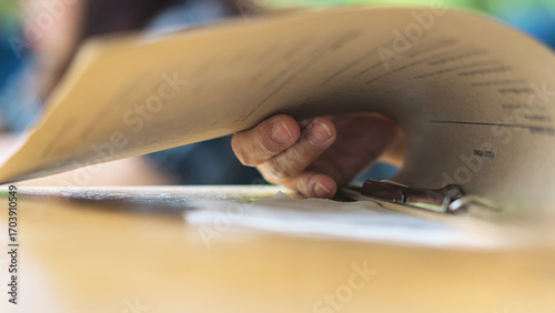 Close up to woman finger with menu choosing dishes at restaurant. A person reading menu at table. Woman with menu in restaurant making order. People select order from menu. Order food through menu.