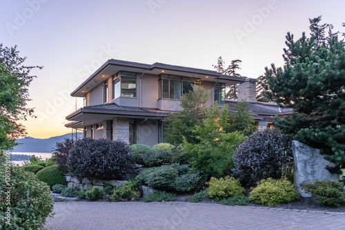 Two story stucco luxury house with big tree and nice landscape at night at Summer in Vancouver, Canada, North America. July 2025.