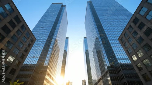 Wallpaper Mural Sunlight glints off modern glass skyscrapers illuminating a bustling city street below Torontodigital.ca