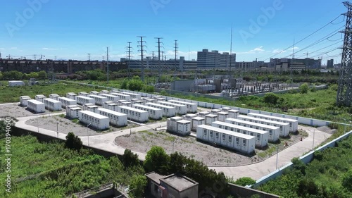 Aerial view of numerous white containers arranged on an open field
