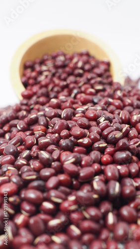 Close-up of red adzuki beans spilling from a wooden bowl, symbolizing healthy legumes, organic food, nutrition, agriculture, and plant-based protein.