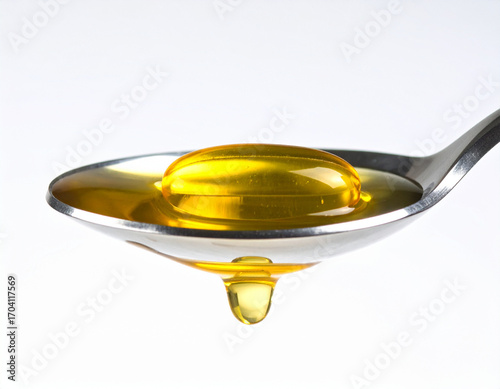 Golden Omega-3 Capsule on Spoon with Dripping Oil, White Background